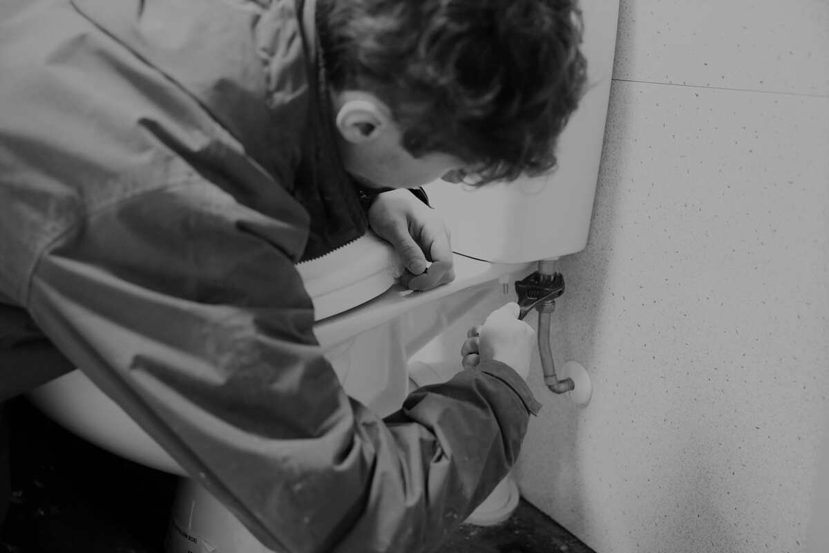 Operative with spanner fixing a toilet