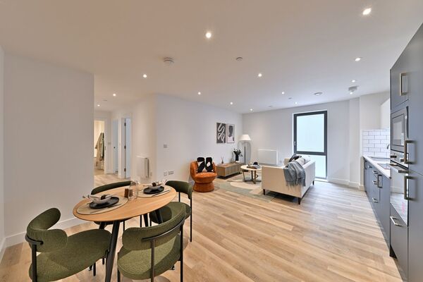 A wide angled photo of a show home, spotlights set into the white ceiling, the room features one frosted window.